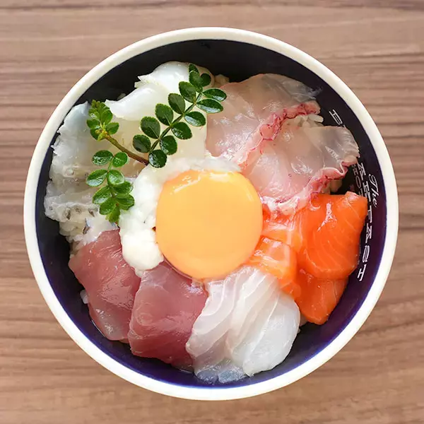 bowl of rice topped with slices of seafood